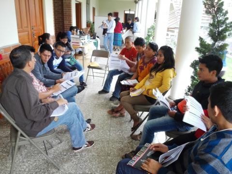 Milvia and her fellow observers in the western region of Guatemala study the observation forms.