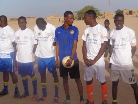  As a confidence-building measure, youth and security forces competed in soccer matches. Local youth here line up before the game in t-shirts printed the occasion, “I want to live in security; trust the Nigerien Security Forces.”
